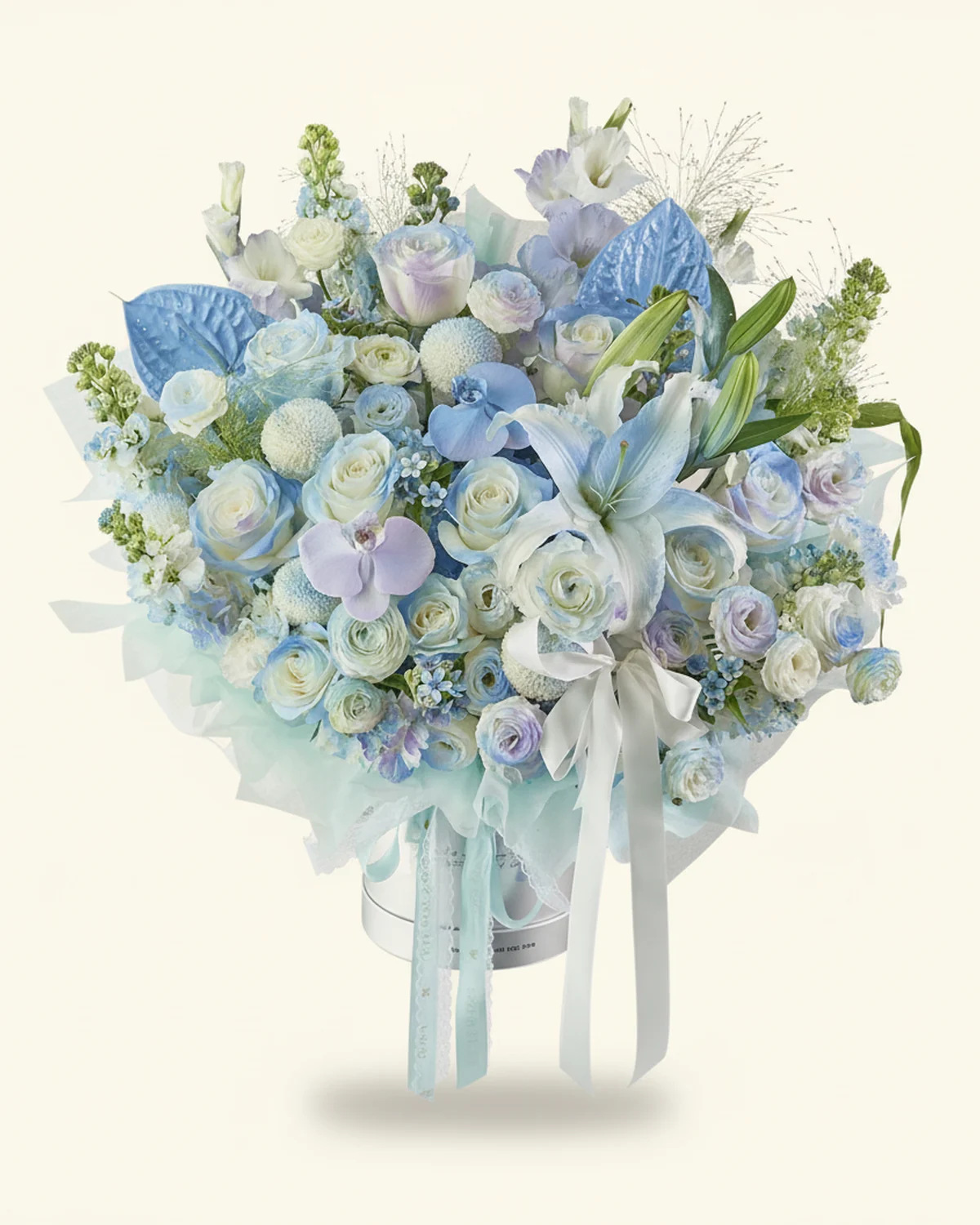 Icy Blue Tribute Flower Bucket — White fragrant lilies — 1 stem (sprayed light blue, 4 heads/stem), Anthuriums, 2 stems, Blue hydrangea — 1 stem, White moth orchids — 2 blooms (sprayed blue-purple), White 'Pride' roses — 11 stems (edges sprayed blue), White ping-pong chrysanthemums — 5 stems (sprayed light blue), Fountain grass — 4 stems, White gladiolus — 3 stems (sprayed blue + light purple), White stock flowers — 7 stems (sprayed blue), White eustoma — 6 stems (4 heads/stem, sprayed slight light purple), Blue star flowers — 5 stems, White ranunculus — 4 stems (sprayed blue), White carnations — 5 stems (sprayed blue), 19.5cm large 'hug' bucket — 1 unit