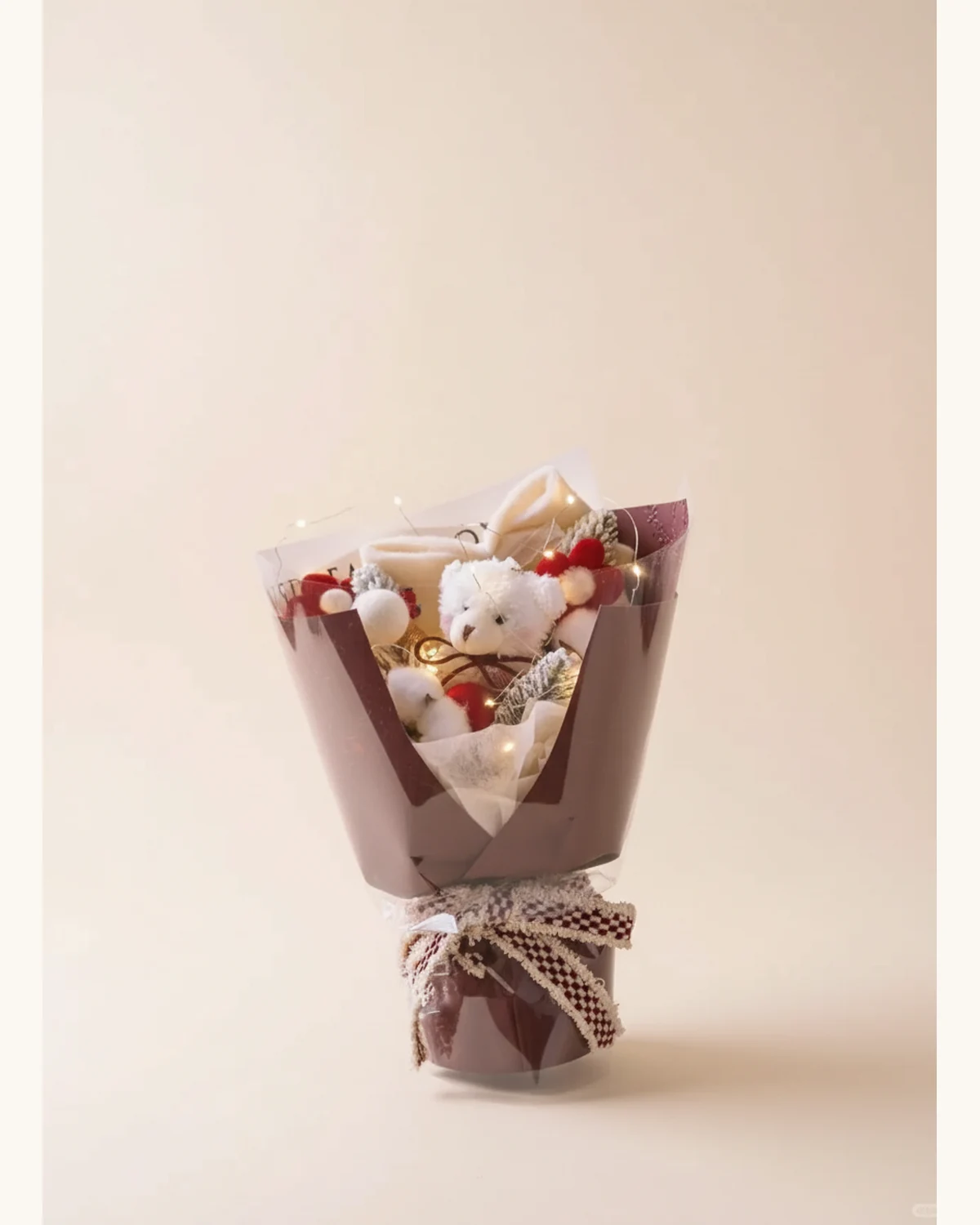 Christmas Teddy Bear Accessory Bouquet — White teddy bear plush, Artificial pine branches, Cotton flowers, LED string lights, Burgundy wrapping paper, Checkered ribbon