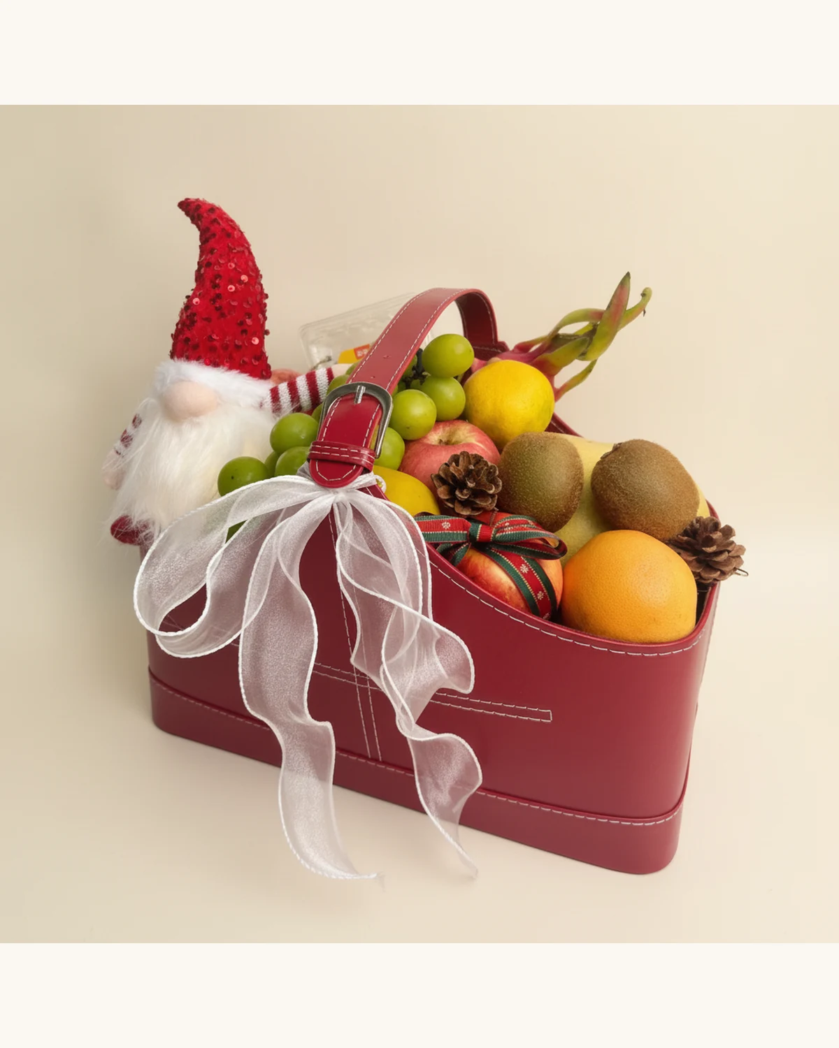 Christmas Red Leather Fruit Basket with Gnome Plush — Red Leather Handheld Basket, Christmas Gnome Plush, Green Grapes, Kiwi Fruit, Apple, Orange, Dragon Fruit, Pine Cones, White Organza Ribbon, Christmas Ribbon