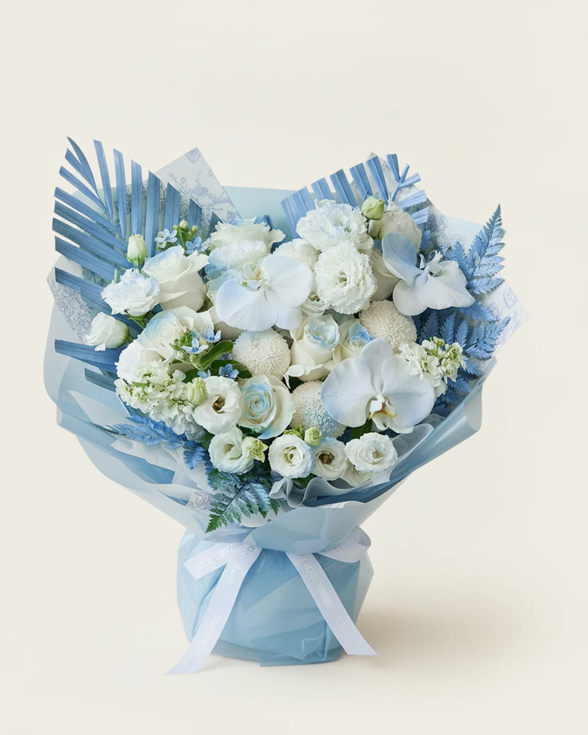 Starlit White Horizon — Pride white roses — 9 stems (centres sprayed light blue), White stock flowers, 2 stems, White ping-pong chrysanthemums — 4 stems (edges sprayed light blue), Curled-edge white eustoma — 5 stems (3+ heads per stem), White phalaenopsis orchids — 3 blooms (edges sprayed light blue), Blue star flowers — 2 stems, Areca palm — 2 stems (edges sprayed light blue), Mountain fern — 4 stems (edges sprayed light blue)