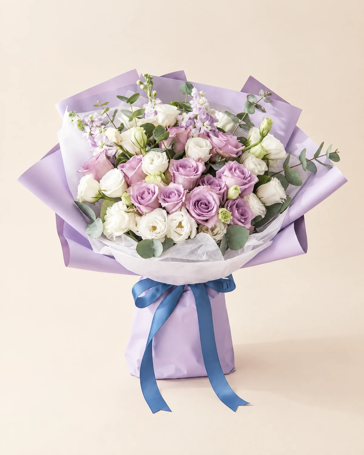 Enchanted Amethyst Bouquet — 11 'Zixia Fairy' purple roses, 10 stems white lisianthus (3+ heads each), 5 eucalyptus stems, Light-purple stock flowers, 3 stems